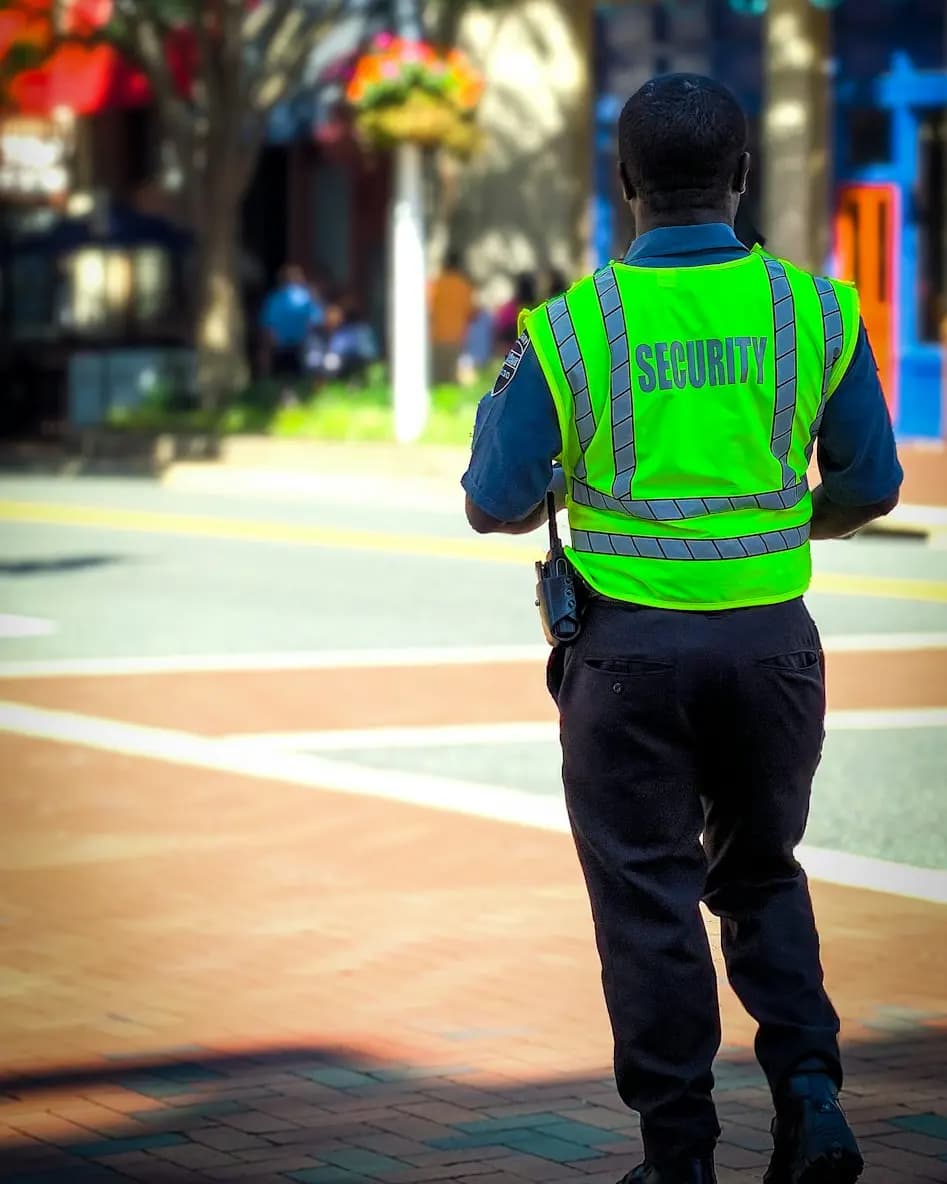 A security guard in a high-visibility vest on patrol